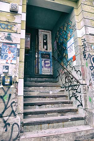 Eingangsbereich mit Graffitis, Plakaten und Aufklebern verschönert